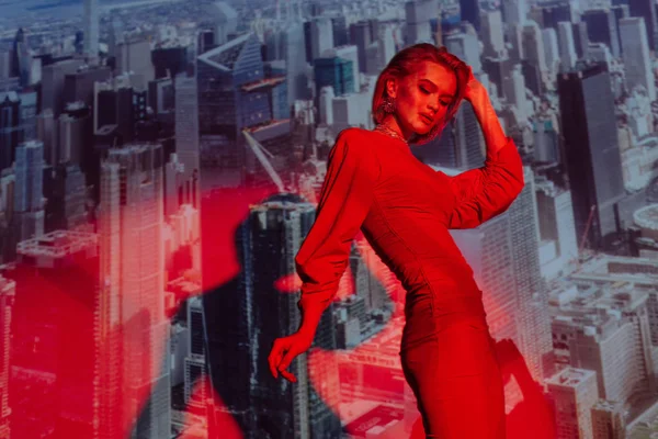 Donna attraente ed elegante in abito rosso sullo sfondo della città — Foto stock