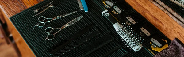 Colpo panoramico di forbici affilate vicino a spazzola di capelli in negozio di barbiere — Foto stock