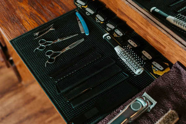 Selective focus of sharp scissors near hair brush in barbershop — Stock Photo