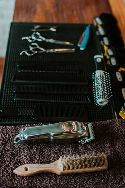 Selective focus of hair brushes near trimmer in barbershop — Stock Photo