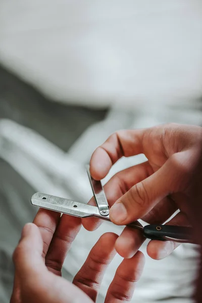 Cropped view of barber holding metallic razor in barbershop — Stock Photo