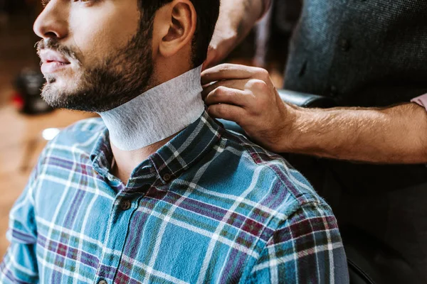 Vista recortada del collar de fijación de peluquero alrededor del cuello del hombre barbudo - foto de stock