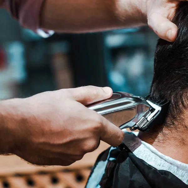 Close-up de barbeiro styling cabelo do homem na barbearia — Fotografia de Stock