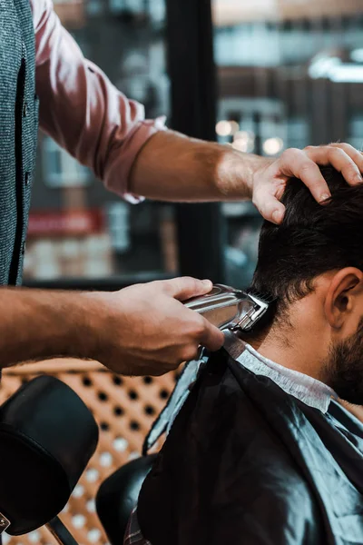 Corte vista de barbeiro styling cabelo do homem na barbearia — Fotografia de Stock