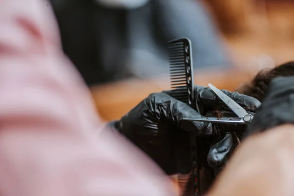 Vista recortada de peluquero corte de pelo de hombre en la barbería - foto de stock