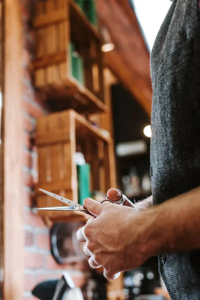 Vista recortada de tijeras de tenencia de peluquería en la barbería - foto de stock