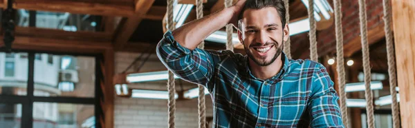 Tiro panorámico de hombre feliz tocando el pelo en la barbería - foto de stock