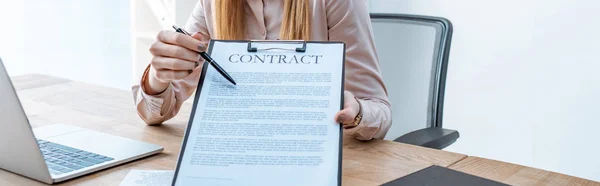 Cropped view of travel agent pointing with pen at contract on clipboard — Stock Photo