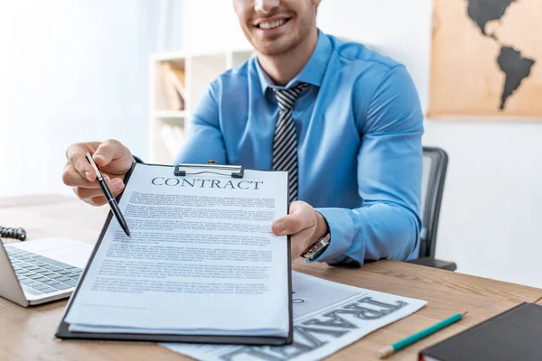 Ausgeschnittene Ansicht eines Reisebüros, das mit Stift auf Vertrag auf Klemmbrett zeigt — Stockfoto