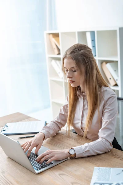 Agent de voyages concentré utilisant un ordinateur portable sur le lieu de travail — Photo de stock