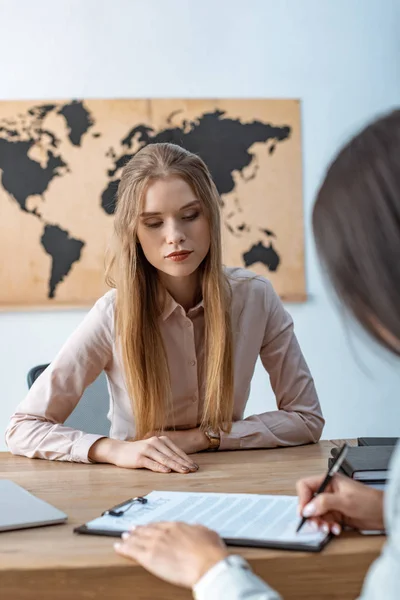 Vue recadrée du client signant le contrat près de l'agent de voyage attentif — Photo de stock