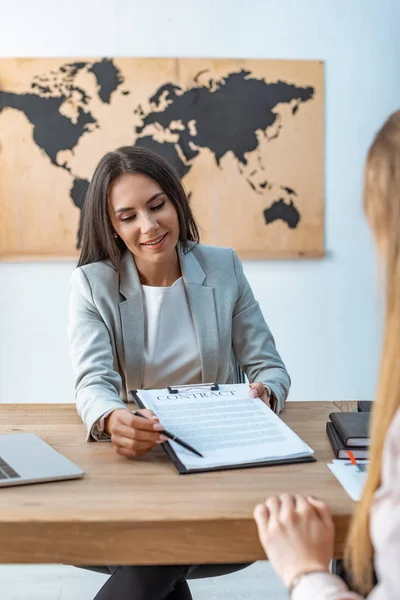 Attraktives Reisebüro zeigt dem Kunden Unterschrift im Vertrag — Stockfoto