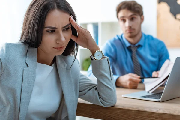 Selective focus of offended woman near discouraged travel agent — Stock Photo