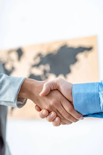Partial view of travel agent and client shaking hands in office — Stock Photo