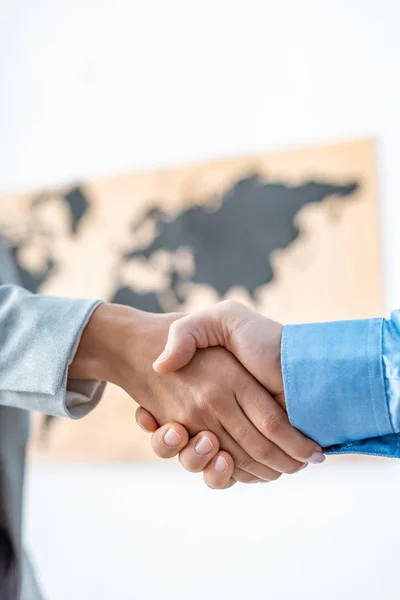 Teilansicht von Reisebüro und Kunde beim Händeschütteln im Büro — Stockfoto