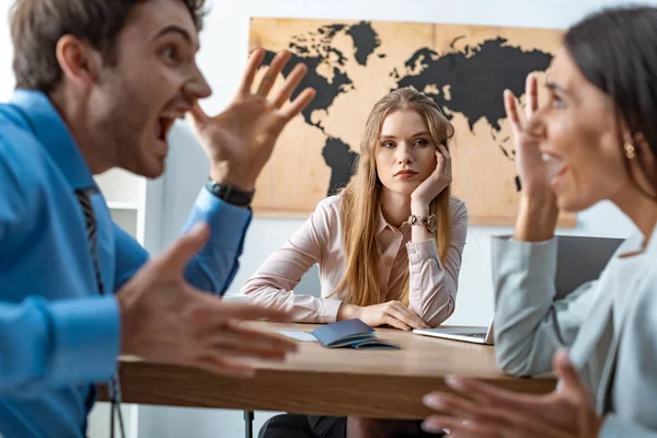 Selective focus of quarreling couple of tourists near bored travel agent — Stock Photo