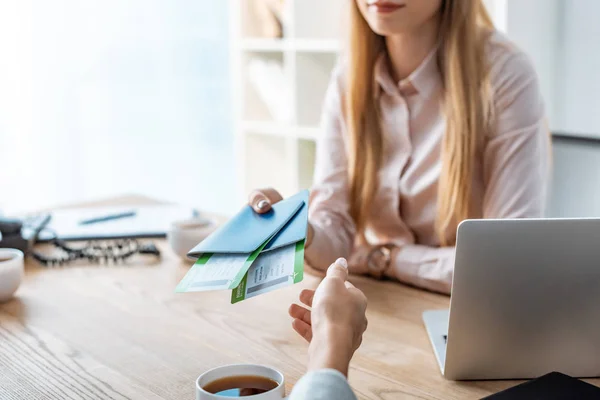 Cropped view of travel manager giving passports and air tickets to client — Stock Photo