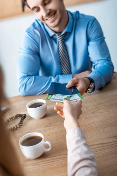 Selective focus of travel agent giving passports and air tickets to client — Stock Photo