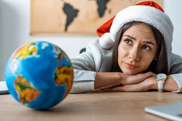 Selective focus of dreamy travel agent near globe at workplace — Stock Photo