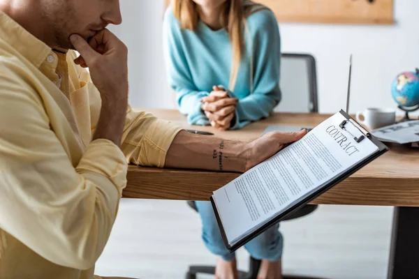 Ausgeschnittene Ansicht eines Mannes, der Vertrag in der Nähe von Reisebüro liest — Stockfoto