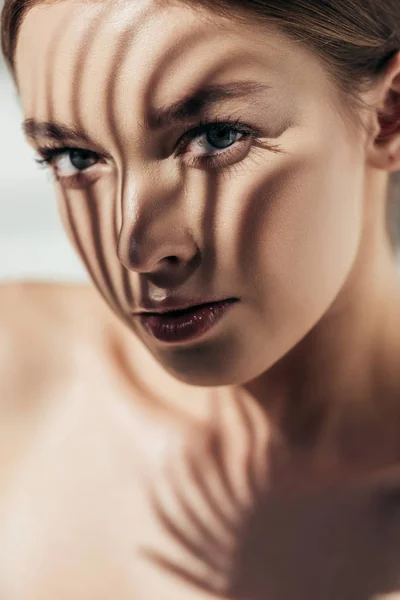 Portrait of beautiful nude girl with shadows on face on grey — Stock Photo