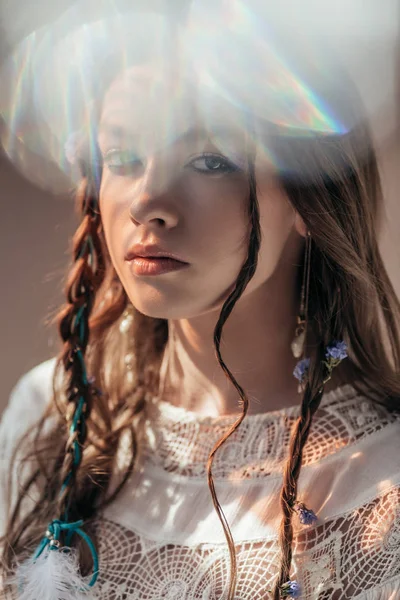 Beautiful girl with braids in hairstyle posing in white boho dress on grey with lens flares — Stock Photo