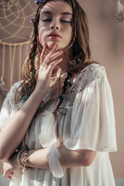 Tender girl with braids and closed eyes on beige with dream catcher — Stock Photo