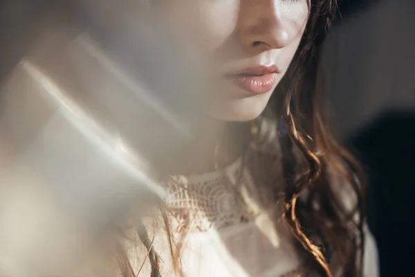 Vista cortada da menina boho com tranças no penteado posando em vestido branco em cinza com flares de lente — Fotografia de Stock