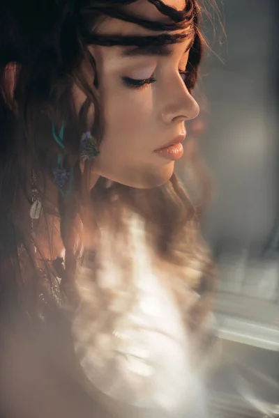 Hermosa chica boho con trenzas en peinado posando sobre gris con bengalas de lente - foto de stock