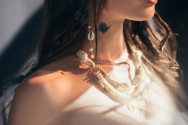 Vista recortada de chica boho desnuda con trenzas en peinado posando sobre gris con bengalas de lente - foto de stock