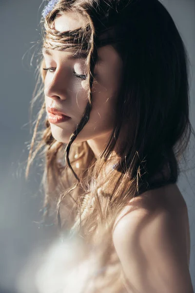 Красива гола дівчина-бохо з косами в зачісці позує на сірому з спалахами лінз — стокове фото