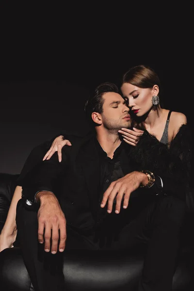 Niedrigwinkel-Ansicht der attraktiven Frau umarmt und küsst schönen Mann isoliert auf schwarz — Stockfoto