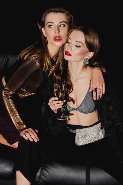 Hochwinkel-Ansicht der attraktiven und stilvollen Frau umarmt Freund mit Champagnerglas isoliert auf schwarz — Stockfoto