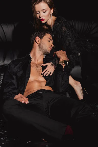 Привлекательная женщина, обнимающая сексуального и красивого мужчину, изолированного от черного — стоковое фото