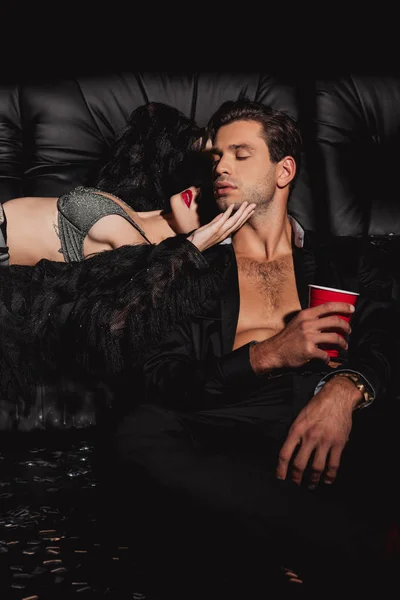 Женщина обнимает сексуального и красивого мужчину, изолированного от черного — стоковое фото