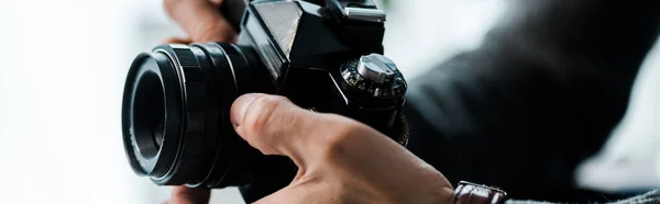 Tiro panorâmico de homem bi-racial segurando câmera digital no apartamento — Fotografia de Stock