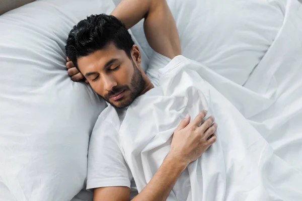 Vue de dessus du bel homme bi-racial dormant au lit le matin — Photo de stock