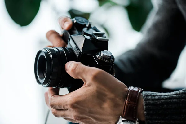 Vista ritagliata di uomo bi-razziale in possesso di fotocamera digitale in appartamento — Foto stock