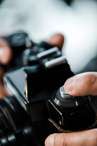 Vista ritagliata di uomo bi-razziale in possesso di fotocamera digitale in appartamento — Foto stock