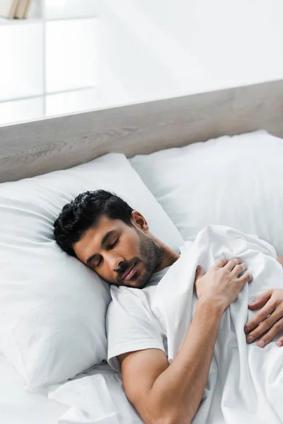 Visão de alto ângulo de belo homem bi-racial dormindo na cama de manhã — Fotografia de Stock