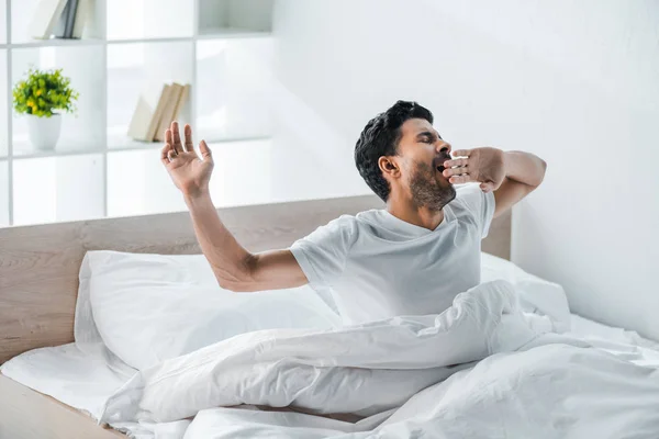 Handsome bi-racial man yawning and waking up in morning — Stock Photo