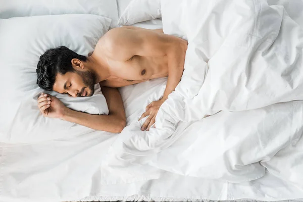 Вид сверху сексуального и красивого мужчины двух рас, спящего в постели по утрам — стоковое фото