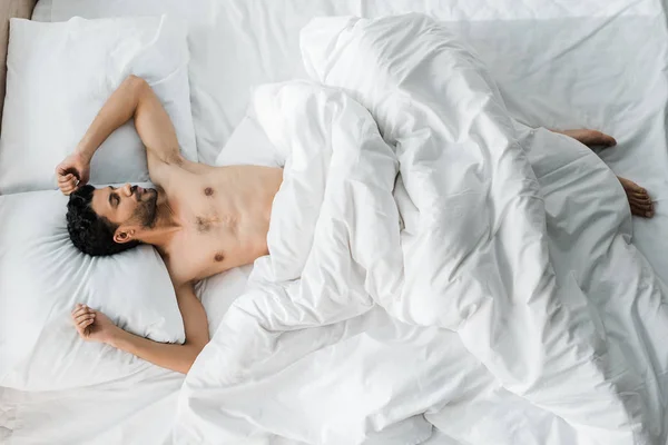Vista superior de sexy e bonito bi-racial homem dormindo na cama de manhã — Fotografia de Stock