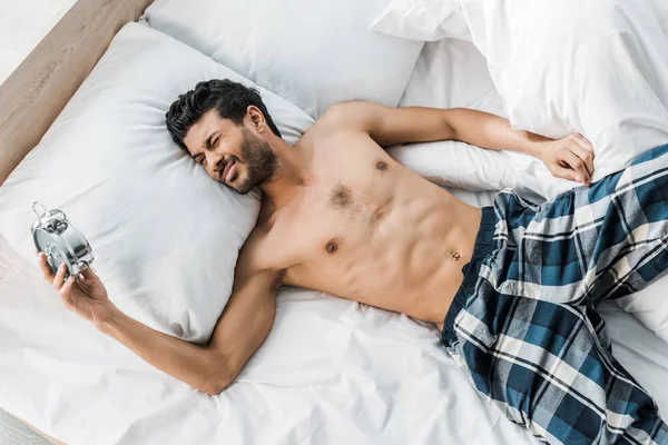 Vista superior de sexy y guapo bi-racial hombre durmiendo en la cama en la mañana - foto de stock
