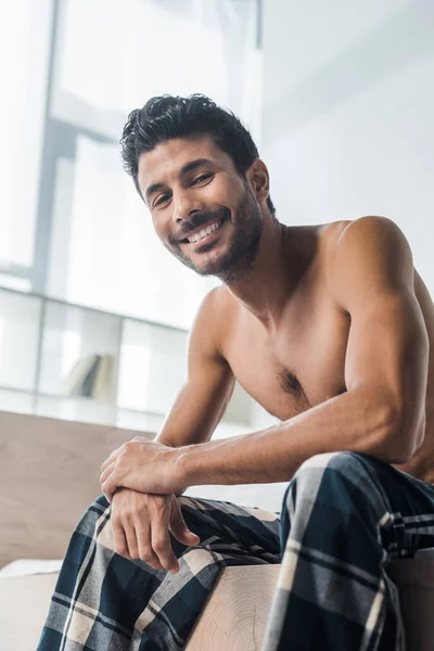 Vista basso angolo di bello e sexy bi-razziale uomo sorridente alla fotocamera al mattino — Foto stock