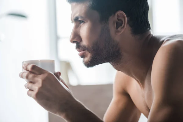 Seitenansicht eines gutaussehenden birassischen Mannes, der morgens eine Tasse Kaffee hält — Stockfoto