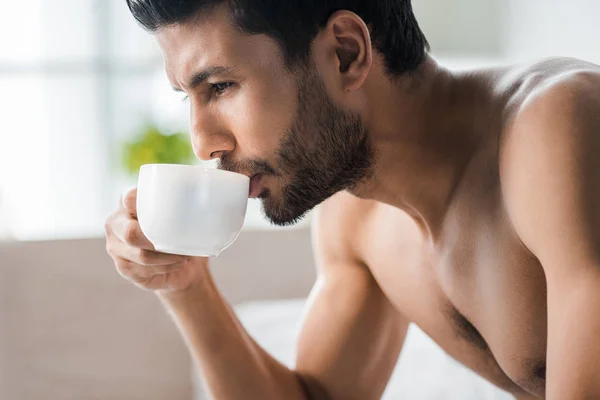 Vista lateral del hombre bi-racial guapo beber café en la mañana - foto de stock