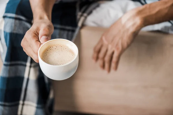 Vue recadrée de l'homme bi-racial tenant une tasse de café le matin — Photo de stock