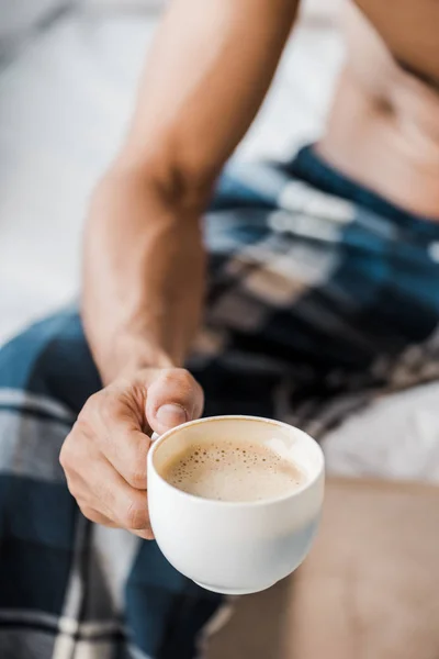 Vista cortada de homem bi-racial segurando xícara de café de manhã — Fotografia de Stock