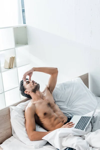 High angle view of handsome and pensive bi-racial man with laptop in morning — Stock Photo